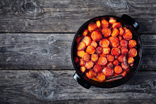 candied sweet potatoes and butter in a black ceramic dish, horizontal view from above